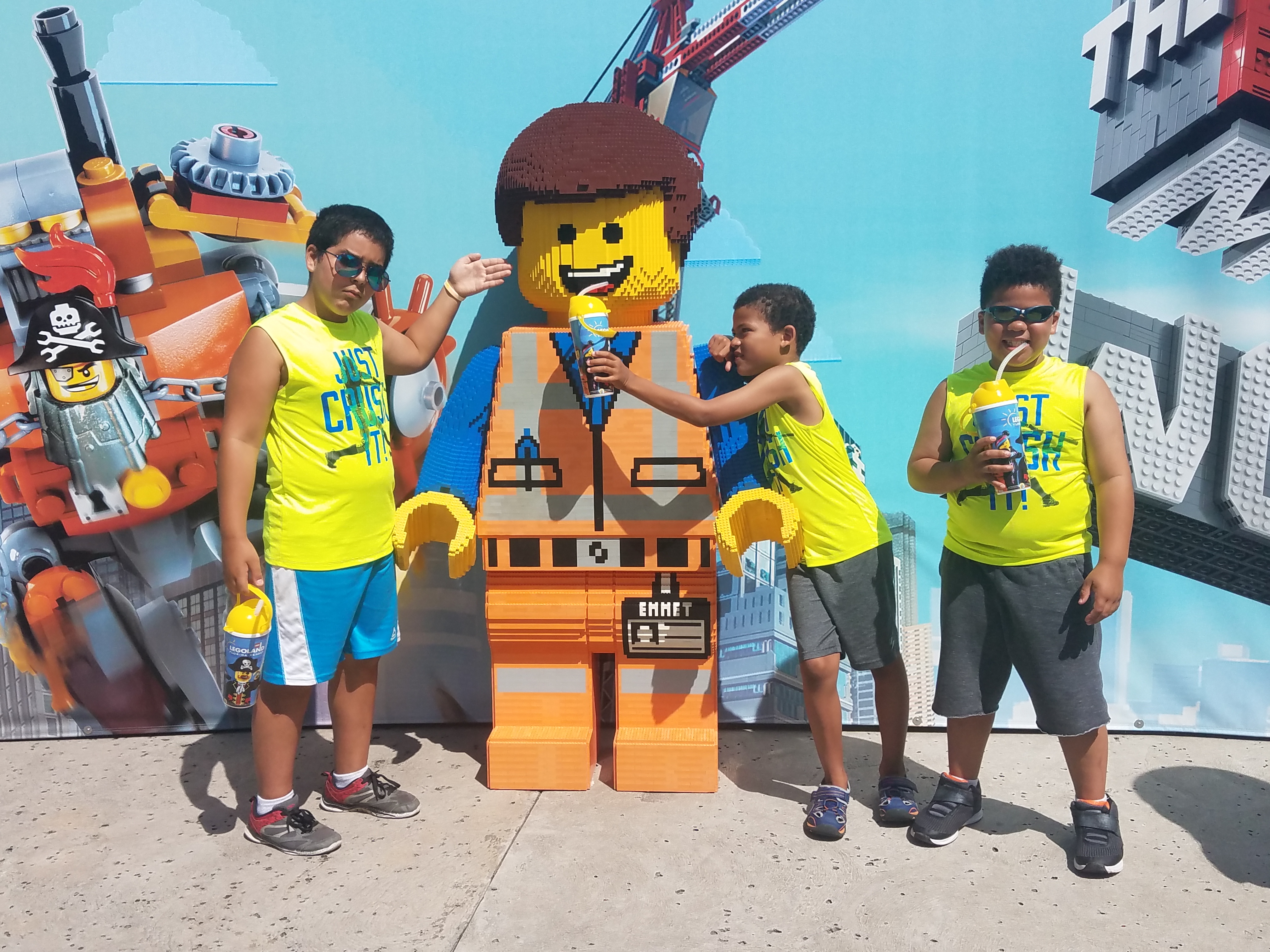 Three brothers enjoy a drink with a LEGO character