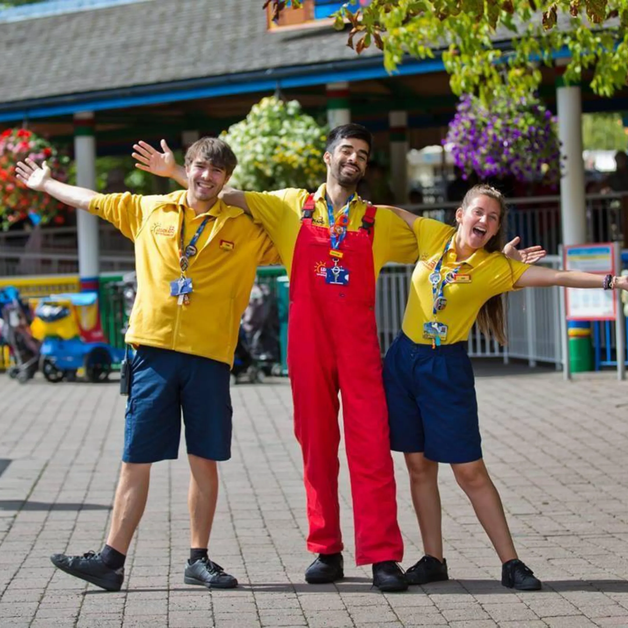 3 LEGOLAND® team members posing with their arms wide open. 