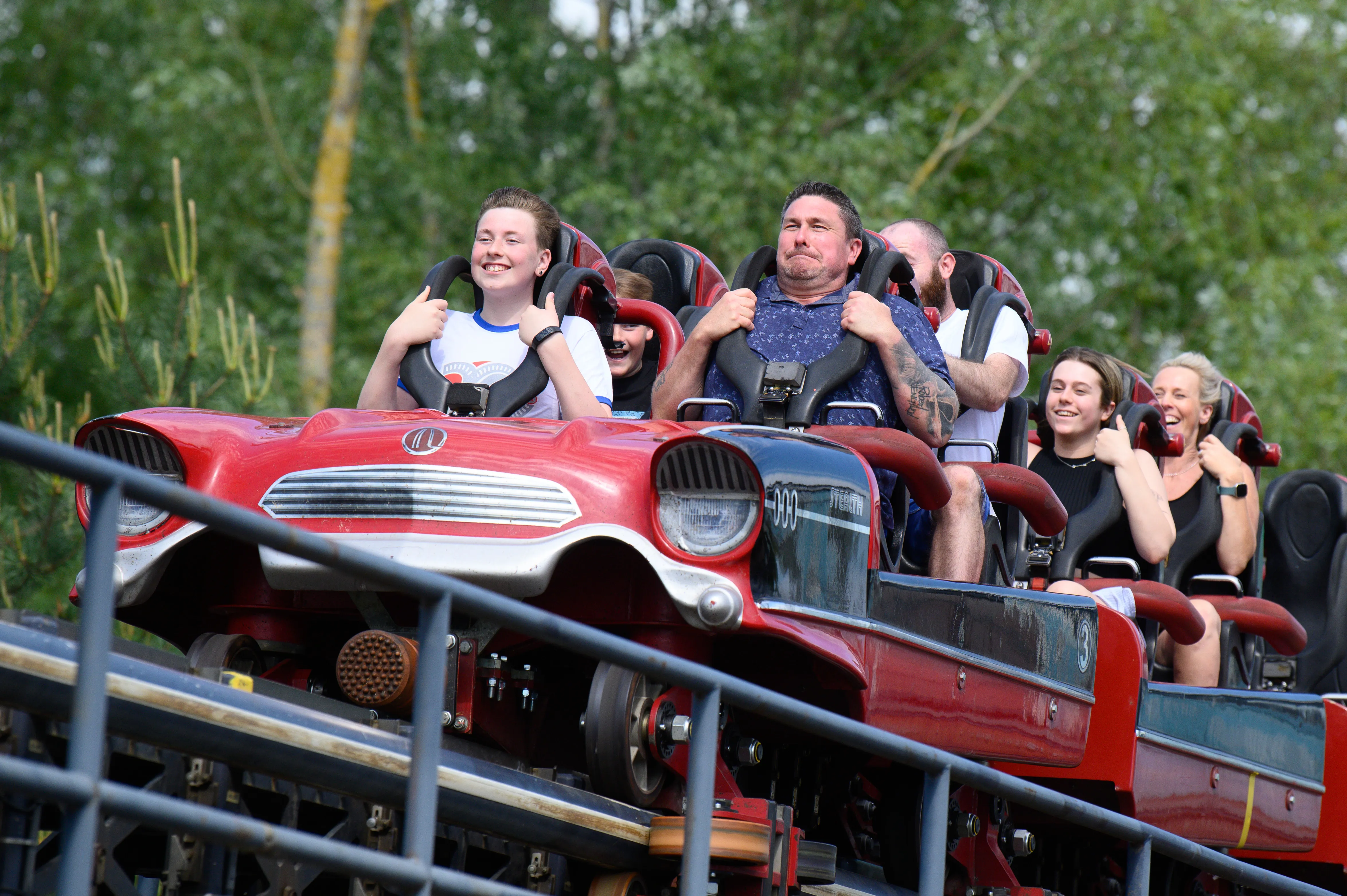 People riding roller coaster