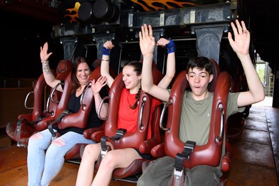 Family putting their arms up preparing for a roller coaster