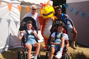 Family and friends posing with mascot on a Magin On Tour